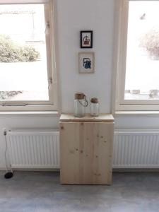 a room with two windows and a wooden crate with jars on it at Tuinhuis in Schagen