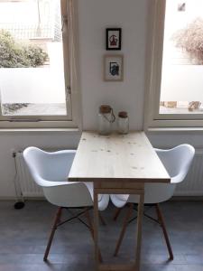einen Tisch und zwei Stühle in einem Zimmer mit zwei Fenstern in der Unterkunft Tuinhuis in Schagen