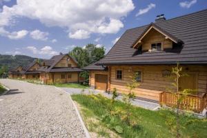rząd drewnianych domów na drodze w obiekcie Mosorny Park Drewniane Komfortowe Domki Całoroczne w Zawoi