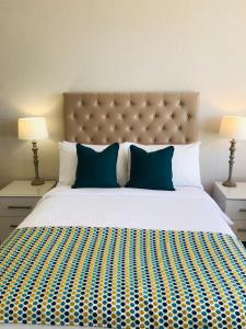 a bedroom with a large bed with blue pillows at Endeavour Guest House in Barmouth