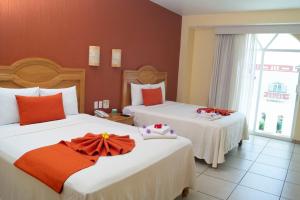 a hotel room with two beds and a window at Casa Danna Huatulco in Santa Cruz Huatulco