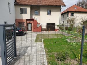 una cerca frente a una casa con un patio en Sašo Rooms & Apartments, en Liubliana