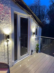 una gran puerta corredera de cristal en una terraza por la noche en Glencree, en Windermere