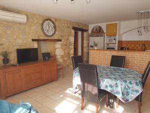 a dining room with a table and a clock on the wall at Bienvenue Chez Romane in Aiguèze