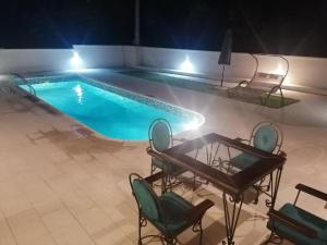a swimming pool at night with chairs and a table at Lux Apartment "Lea" in Kotor +12 photos