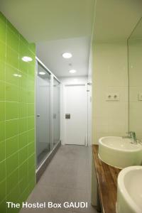 bagno con lavandino, doccia e specchio di Rocket Hostels Gracia a Barcellona