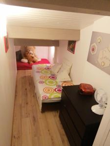 a teddy bear sitting on a bed in a room at Gîte vacances Bosc d'esquirol 4 pers in Escorneboeuf