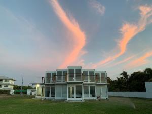 a white house with a rainbow in the sky at Nomada Republic Hotel Punta Chame in Punta Chame