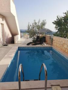 a large blue swimming pool with two metal bars at Apartment Sunset in Šibenik