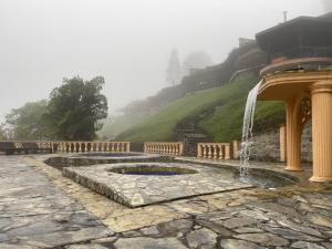 a stone patio with a fountain in front of a hill at Rancho San Antonio in Salento