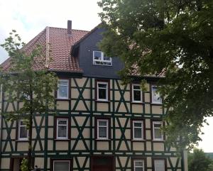 una casa en blanco y negro con techo negro en Ferienwohnung Am Anger, en Diedorf