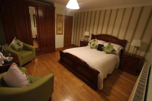 a bedroom with a bed and a couch and a chair at Woodlands Guest Accomadation in Oughterard