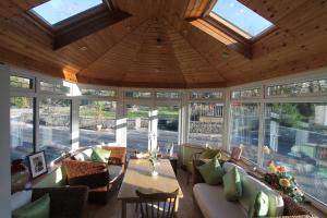 a living room with a lot of windows and a table at Woodlands Guest Accomadation in Oughterard