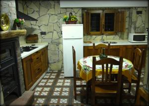 Il comprend une cuisine équipée d'une table et d'un réfrigérateur blanc. dans l'établissement Alojamiento rural La Hontana, à Castillo de Locubín
