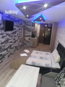 um quarto com uma cama, um sofá e uma televisão em "При братята" - Apartments & Studios em Sandanski