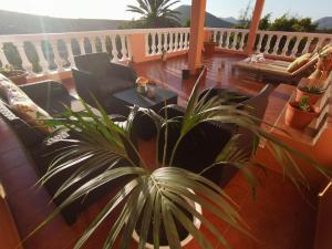 a patio with chairs and a potted plant on a balcony at Casa LA GUALJAMA Tesejerague in Tesejerague