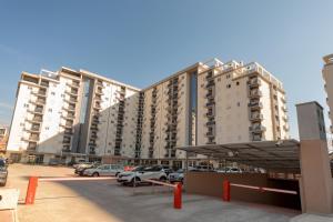 a large building with cars parked in a parking lot at Les appartements Privés Bar in Bar