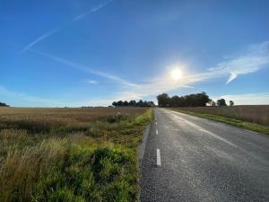 an empty road in the middle of a field at BRICK Österlen in Simrishamn +5 photos
