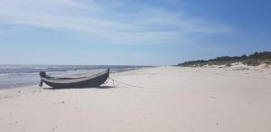 a boat sitting on the sand on a beach at BRICK Österlen in Simrishamn
