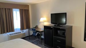 a hotel room with a bed and a desk with a television at La Quinta Inn by Wyndham Cincinnati North in Springdale