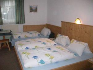キルヒベルク・イン・チロルにあるAppartements Renateのベッドルーム1室(シーツに花を飾ったベッド2台付)