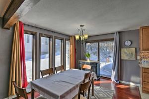 a dining room with a table and chairs and windows at Anchorage Escape about Near Downtown and Fishing! in Anchorage