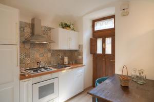 cocina con armarios blancos y mesa de madera en Appartamento la Fortezza en Volterra