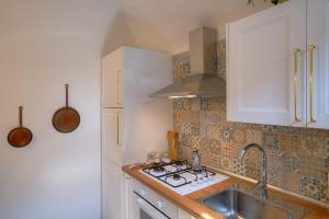 cocina con fregadero y fogones en Appartamento la Fortezza en Volterra