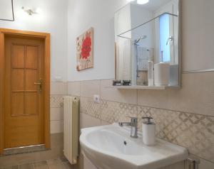 y baño con lavabo y espejo. en Appartamento la Fortezza en Volterra