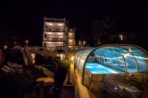 a swimming pool with a glass house at night at Apartment Crikvenica, Vinodol 10 in Sopaljska