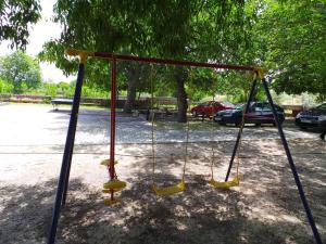 a swing set in a park with cars parked at Apartment Crikvenica, Vinodol 10 in Sopaljska