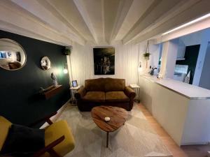 een woonkamer met een bank en een tafel bij Charmant et spacieux studio (T1bis) - Bordeaux, Chartrons in Bordeaux