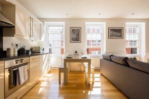 a kitchen with a table and a couch at Contemporary 1 Bedroom Bloomsbury Apartment in London