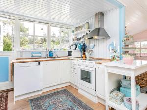 uma cozinha com armários brancos e um forno com placa de fogão em 4 person holiday home in Thisted em Thisted