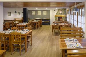 a restaurant with wooden tables and chairs and a fireplace at Hotel Intermonti in San Martín de los Andes +24 photos