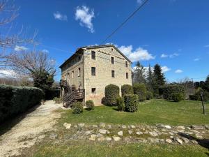 an old stone building on a field with bushes at Magnificent Holiday Home in Amandola with 2 Private Pools in Amandola