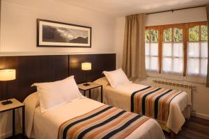 Habitación de hotel con 2 camas y ventana en Hotel Intermonti en San Martín de los Andes