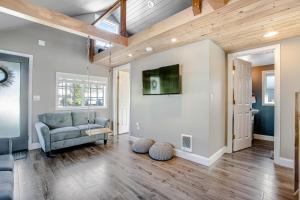 a living room with a couch and a tv on a wall at Siletz Bay Getaway in Lincoln City