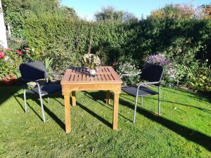 a wooden table and two chairs in a garden at The Fishers @33 in Geraldine