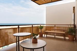 einen Balkon mit 2 Tischen und einer Bank in der Unterkunft Norte Suites Boutique in Los Órganos