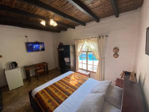 a bedroom with a bed and a tv and a window at Hotel Puerto Gaviota in Tonsupa