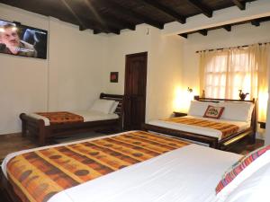 a bedroom with two beds and a tv on the wall at Hotel Puerto Gaviota in Tonsupa