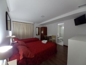 una camera da letto con un letto rosso e un soggiorno di Hotel San Carlos a Buenos Aires