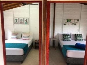 two beds in a room with two windows at Cabañas Veracruz3 Cerritos in Pereira