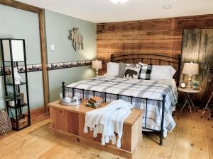 a bedroom with a bed and a wooden wall at Inn on Golden Pond in Holderness