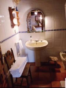 y baño con lavabo, espejo y aseo. en Casa Lucia en Mogarraz