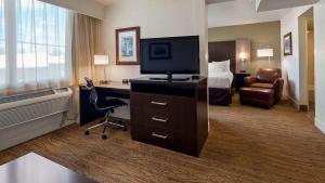 Habitación de hotel con escritorio, TV y cama en Best Western Pony Soldier Inn & Suites, en Flagstaff