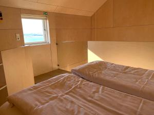 a small room with a bed and a window at Sunnuhlid houses in Akureyri