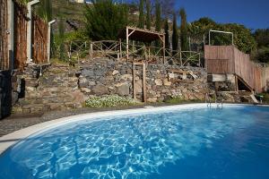 a large blue swimming pool in front of a stone wall at Ga281 in Funchal