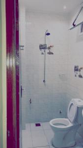 a bathroom with a toilet and a shower at Chambre SEJOUR in Dakar